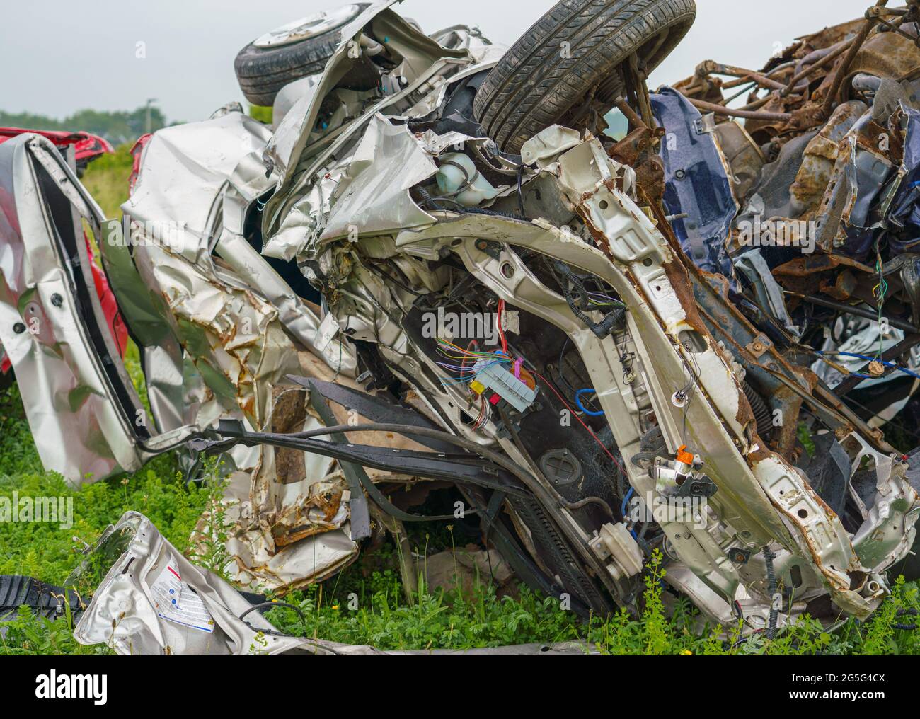 Die zerquetschten Überreste eines Autos, nachdem ein Armeepanzer absichtlich darüber gefahren ist und nur noch Schrott hinterlassen hat Stockfoto