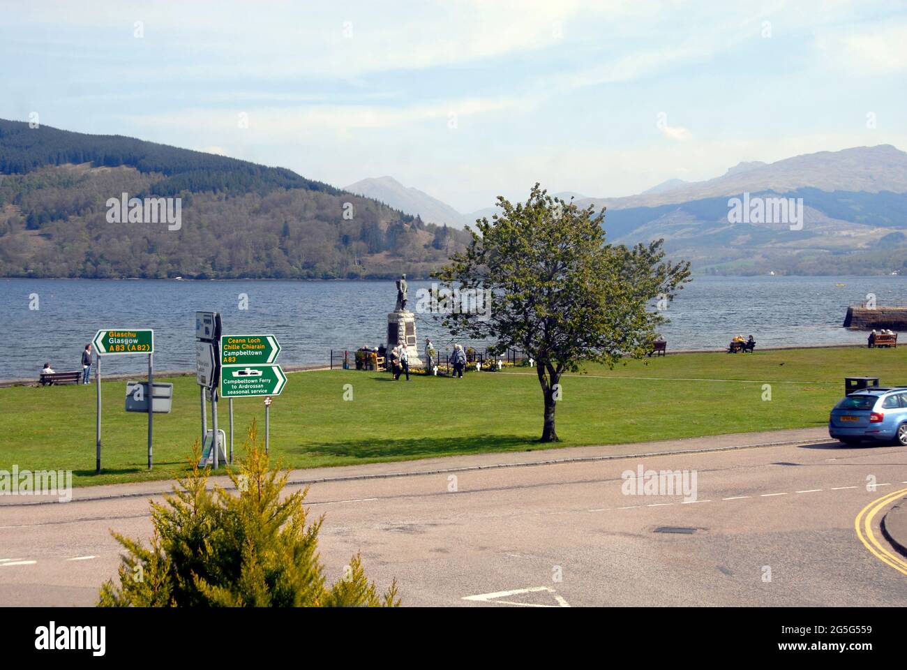 Attraktive Landschaft in Inveraray, Argyll & Bute, Schottland, mit Grünflächen am Wasser mit einem Kriegsdenkmal, mit Blick auf Loch Fyne und die Berge dahinter Stockfoto