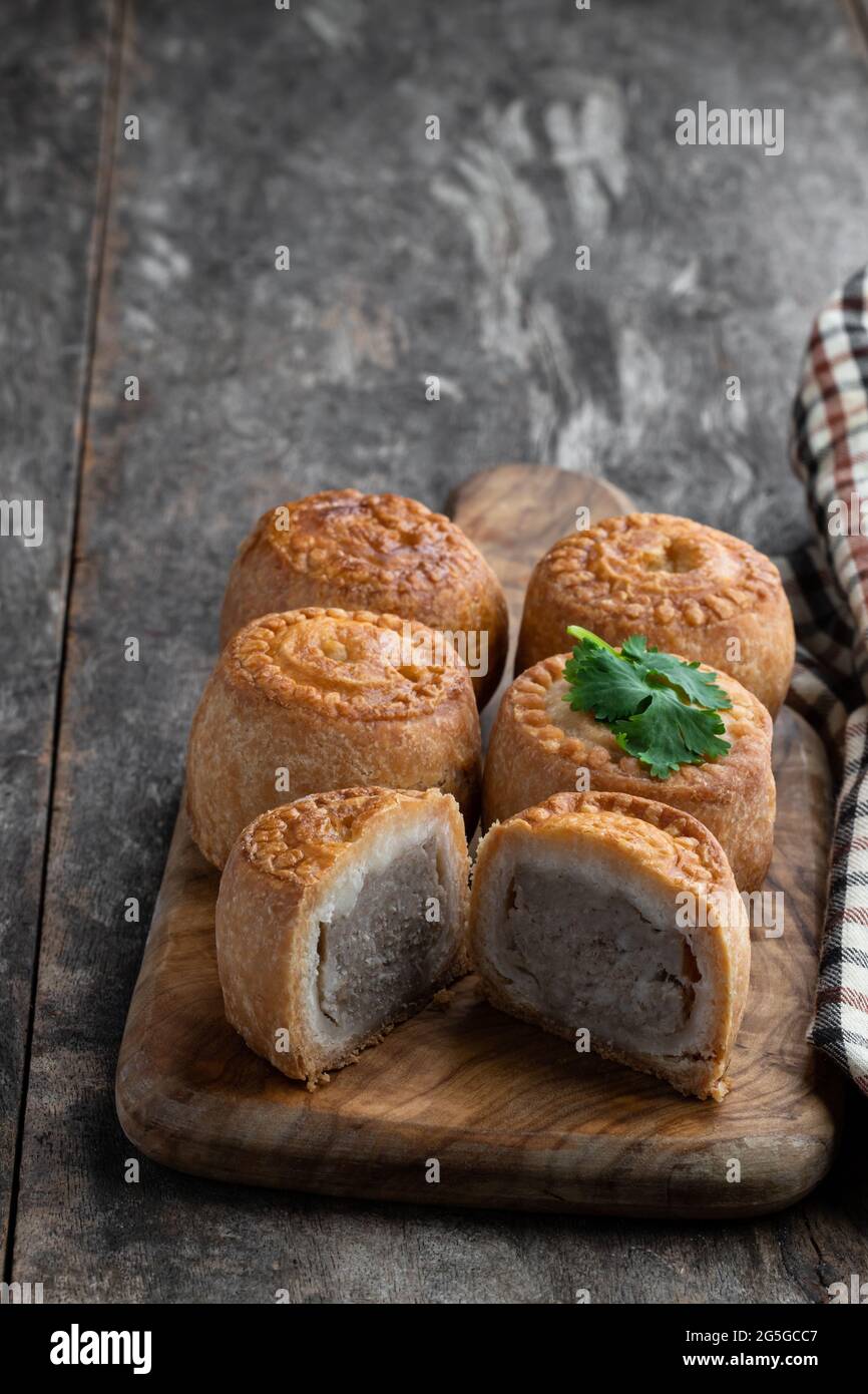 Mini Melton Mowbray Schweinebraten auf rustikalem Holztisch Stockfoto