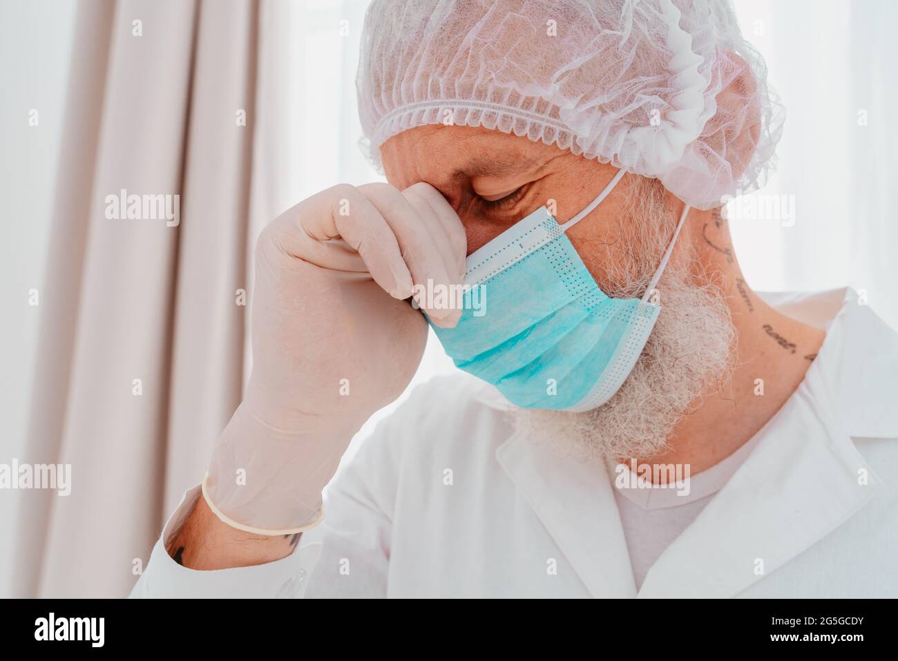 Arzt mit Gesichtsmaske und Gesichtsschutz ist müde von der Covid-19-Virus-Pandemie Stockfoto