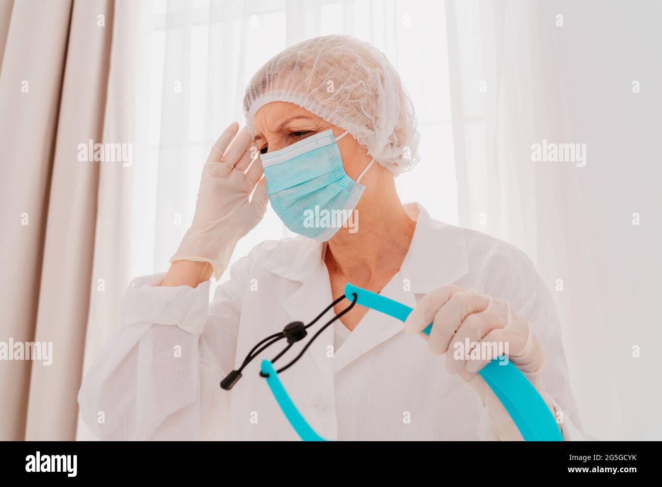 Arzt mit Gesichtsmaske und Gesichtsschutz ist müde von der Covid-19-Virus-Pandemie Stockfoto