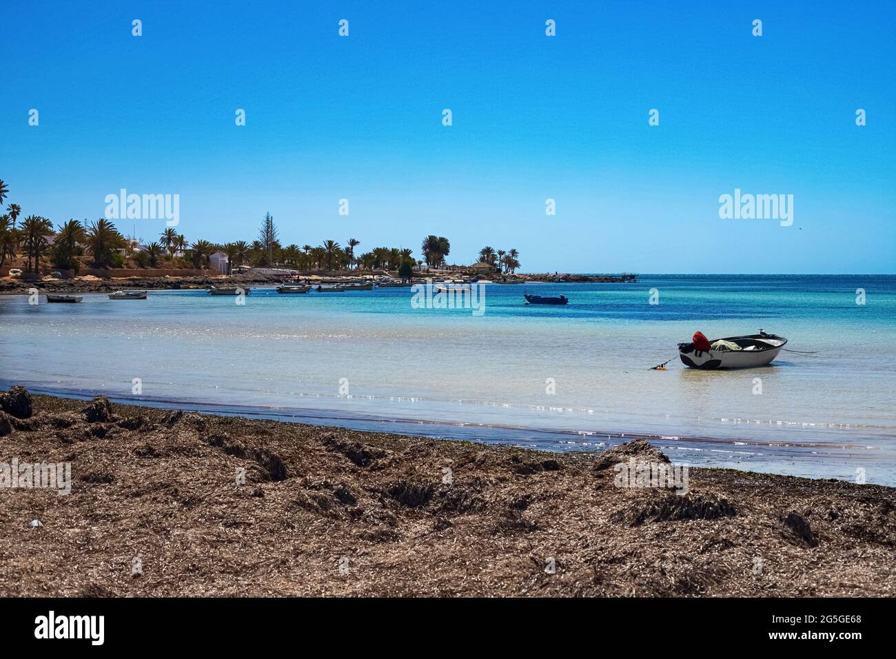 Herrliche Aussicht auf die Mittelmeerküste mit Birkenwasser, weißem Sandstrand und einem Fischerboot Stockfoto