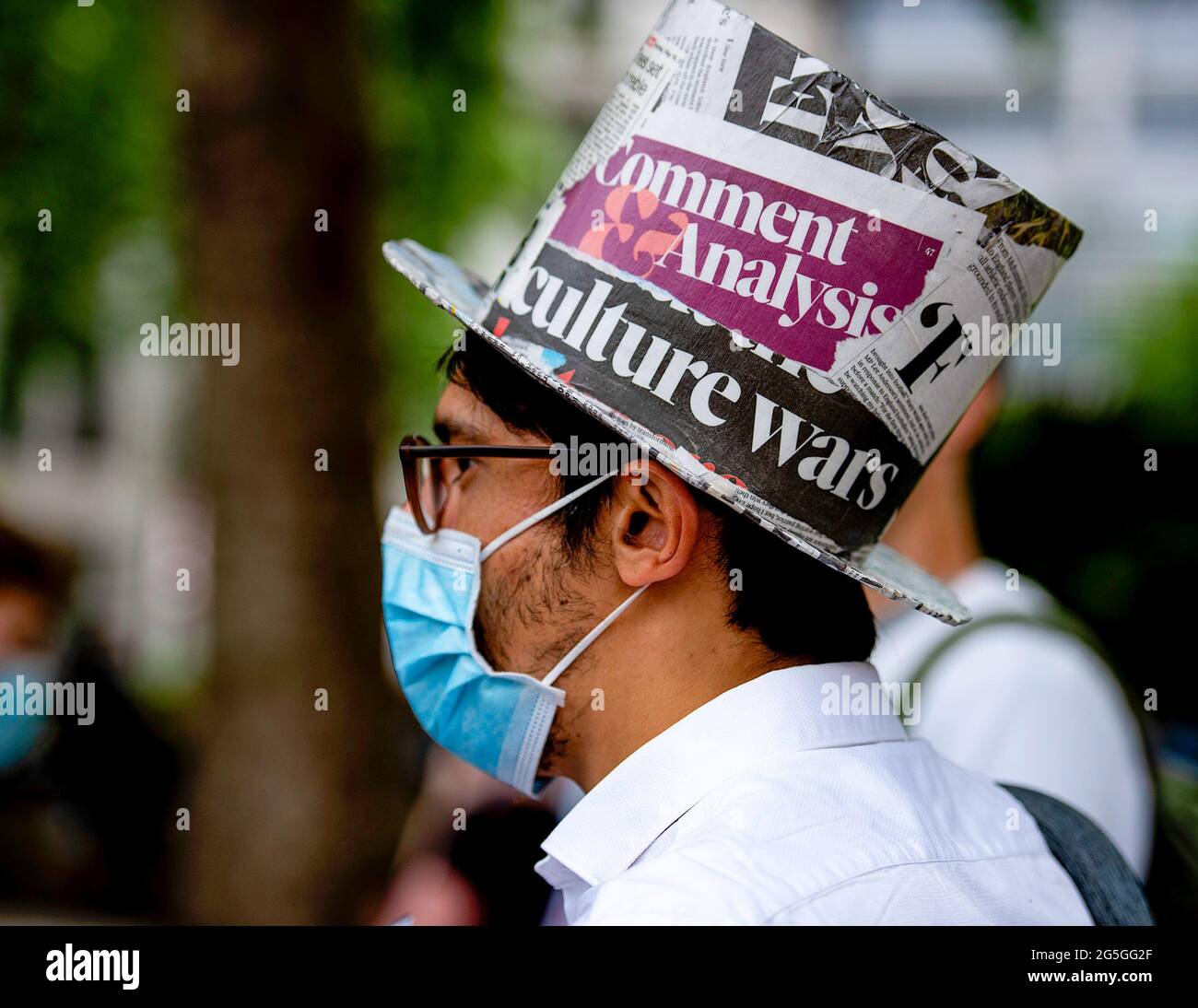 Ein Aktivist trägt einen Hut, der in Zeitungsausschnitten während des  Protestes der Freien Presse in London entworfen wurde. Nachdem die korrupte  Milliardärspresse, die von unserer Spaltung profitiert und die Wahrheit  über die