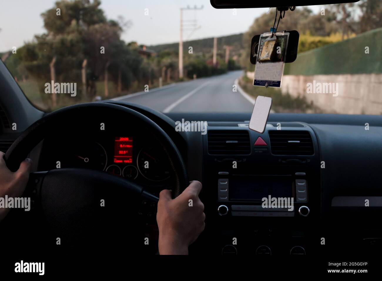 Der Mann, der das Lenkrad mit beiden Händen hält, fährt auf Asphalt. Vorsichtiger Fahrer für sicheres Fahren. Stockfoto