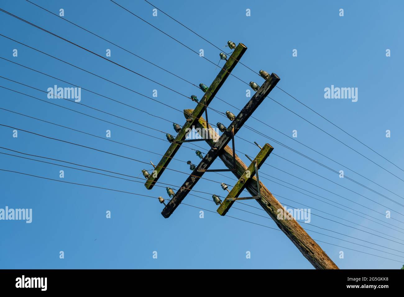 Ein hölzerner, elektrischer Mast an den Bahngleisen Stockfoto