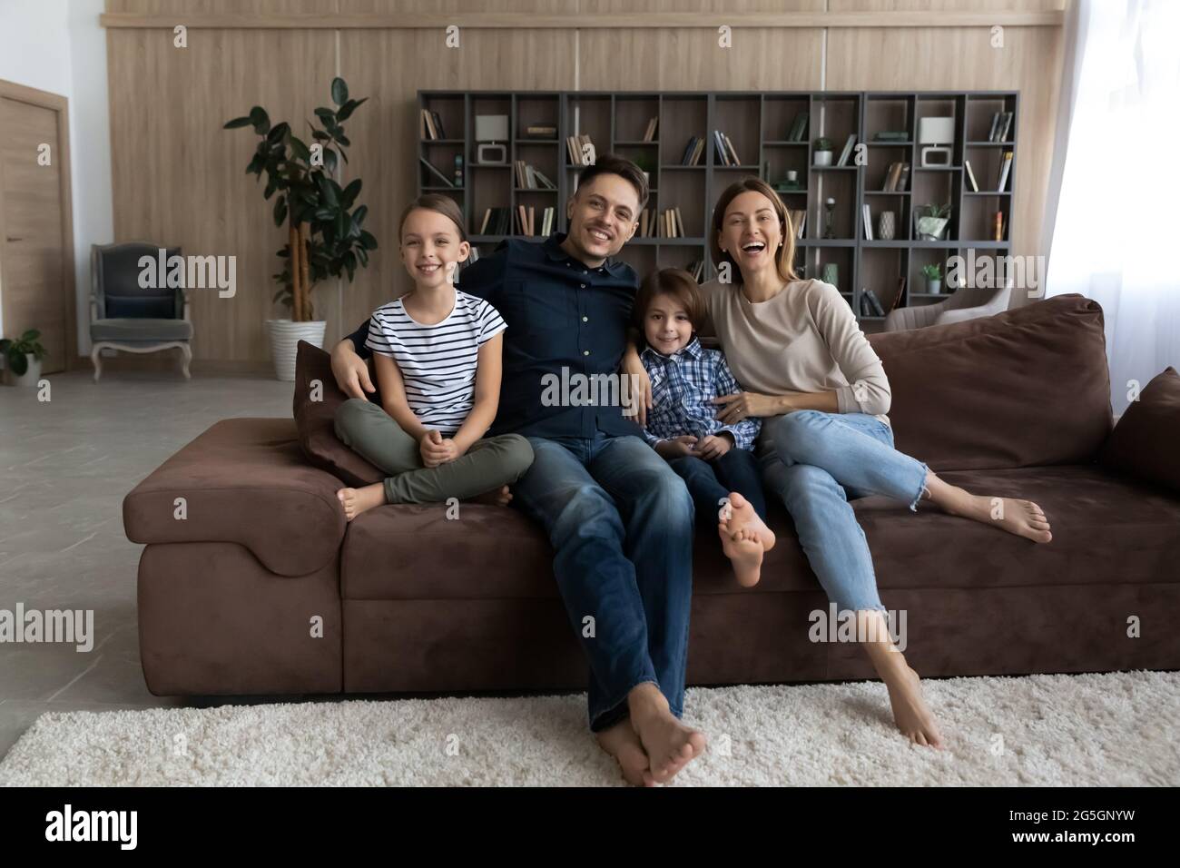 Porträt einer lächelnden Familie mit Kindern Entspannen Sie sich auf dem Sofa Stockfoto