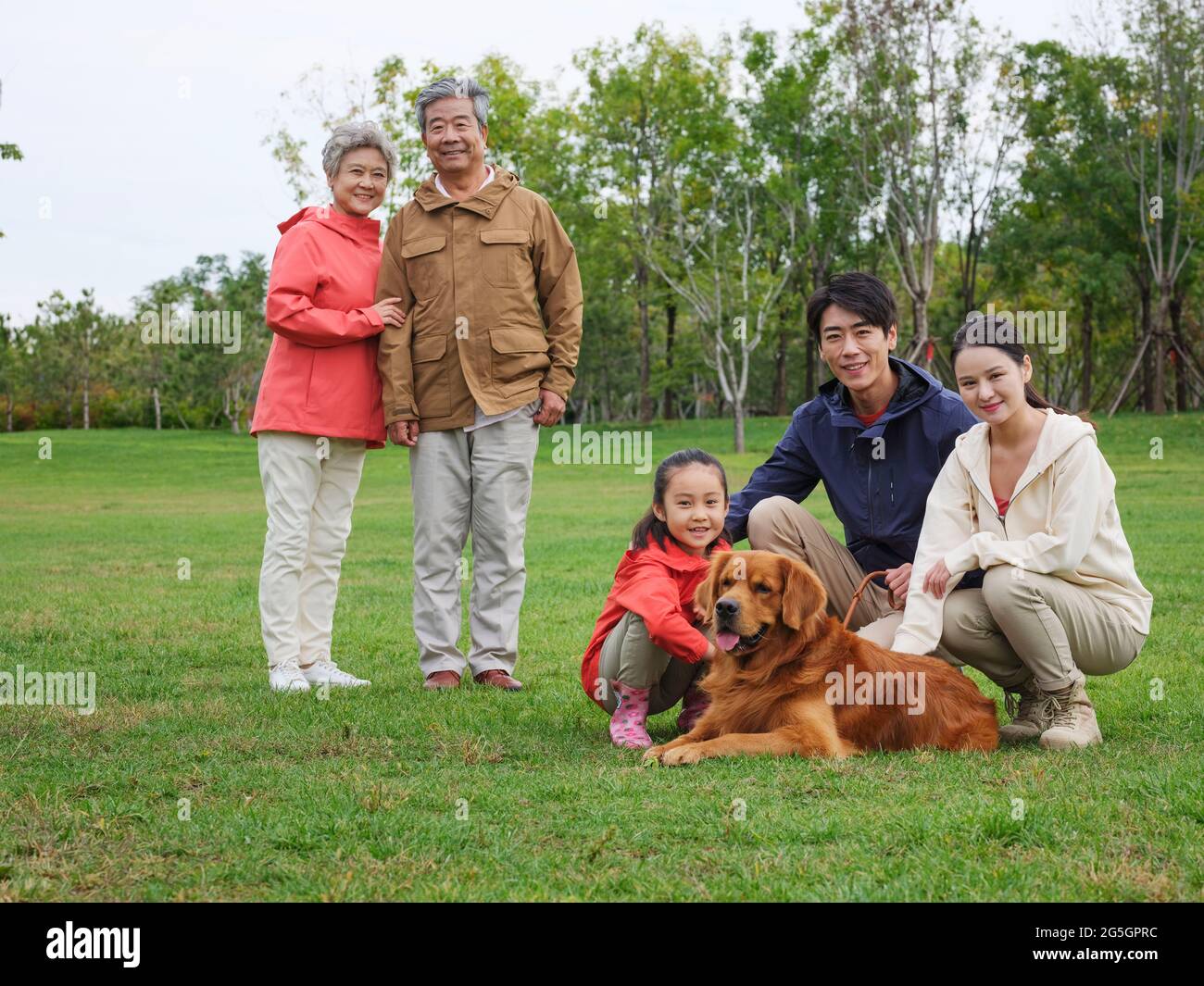 Glückliche Familie von fünf und Haustier Hund spielt im Park hochwertige Foto Stockfoto