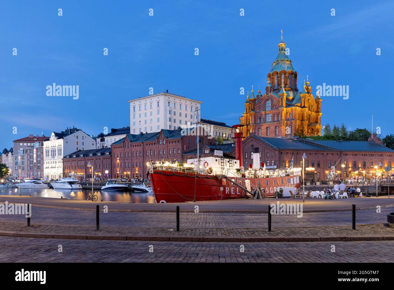 Spektakuläre rote Backsteinkathedrale, die in der finnischen Sommernacht in Helsinki beleuchtet wird Stockfoto