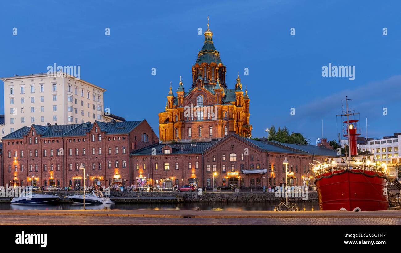 Spektakuläre rote Backsteinkathedrale, die in der finnischen Sommernacht in Helsinki beleuchtet wird Stockfoto