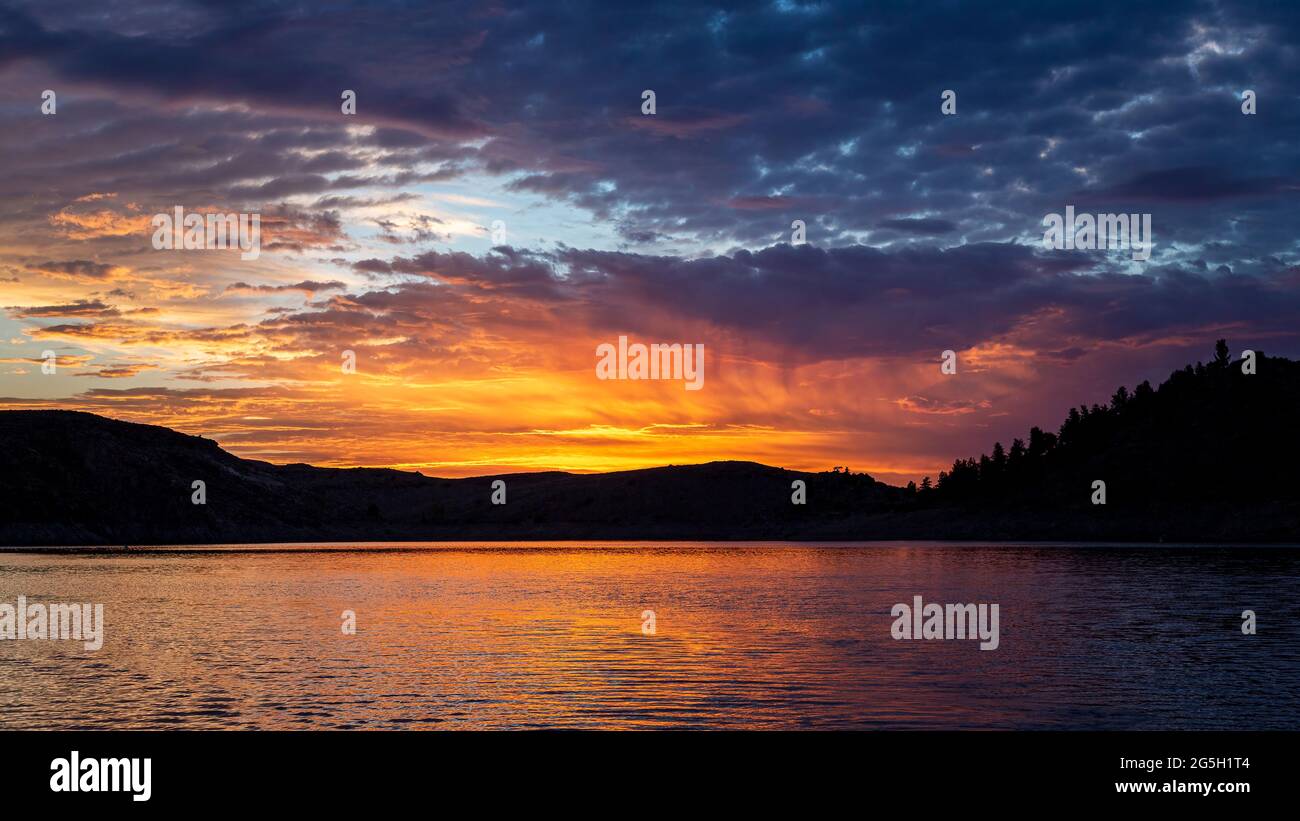 Farbenprächtiger Sonnenaufgang über dem ruhigen See Stockfoto