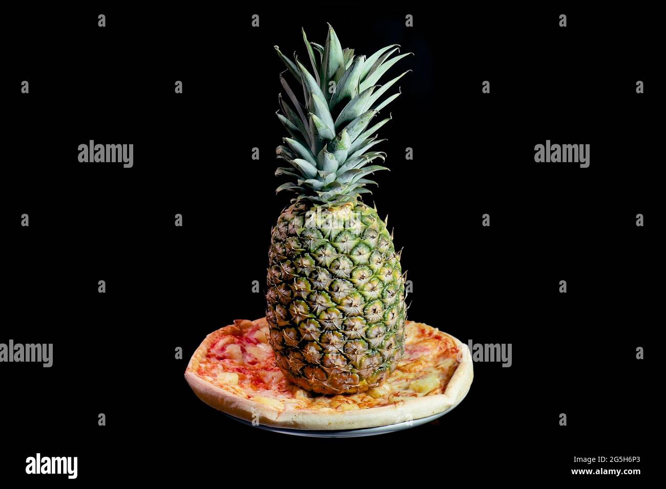 Pizza dreht sich mit einer ganzen Ananas darauf Stockfoto