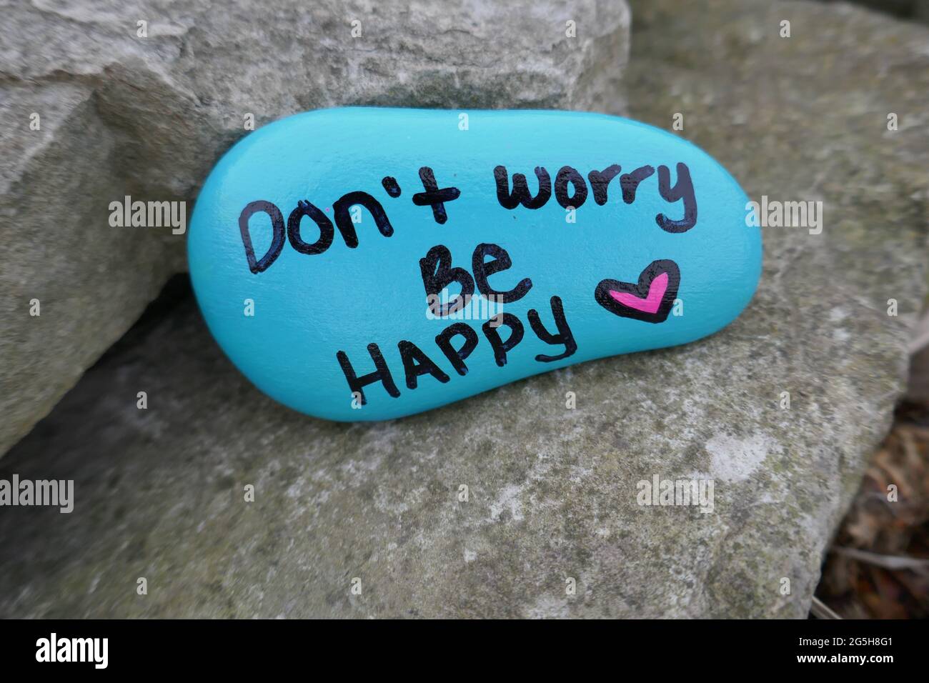 Mach dir keine Sorgen sei glücklich und valentine Herz auf Freundlichkeit Rock gemalt Stockfoto