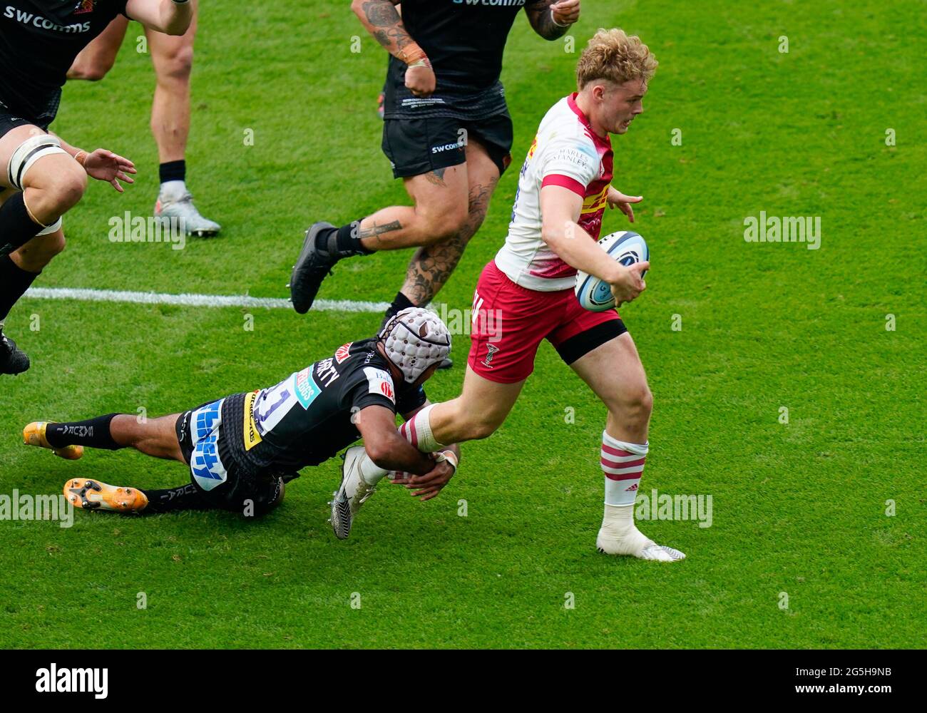 Harlekin-Flügel Louis Lynagh bricht während des Gallagher Premiership Rugby Finales, Exeter Chief, durch das Tackle von Exeter Chiefs-Flügel Tom O'Flaherty Stockfoto