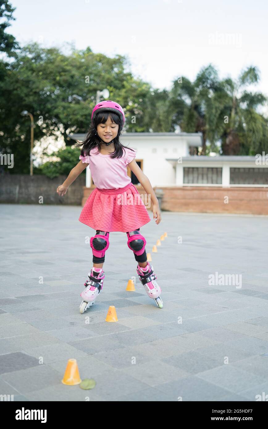 asiatische Mädchen gehen auf ihre in-line-Schlittschuhe Stockfoto