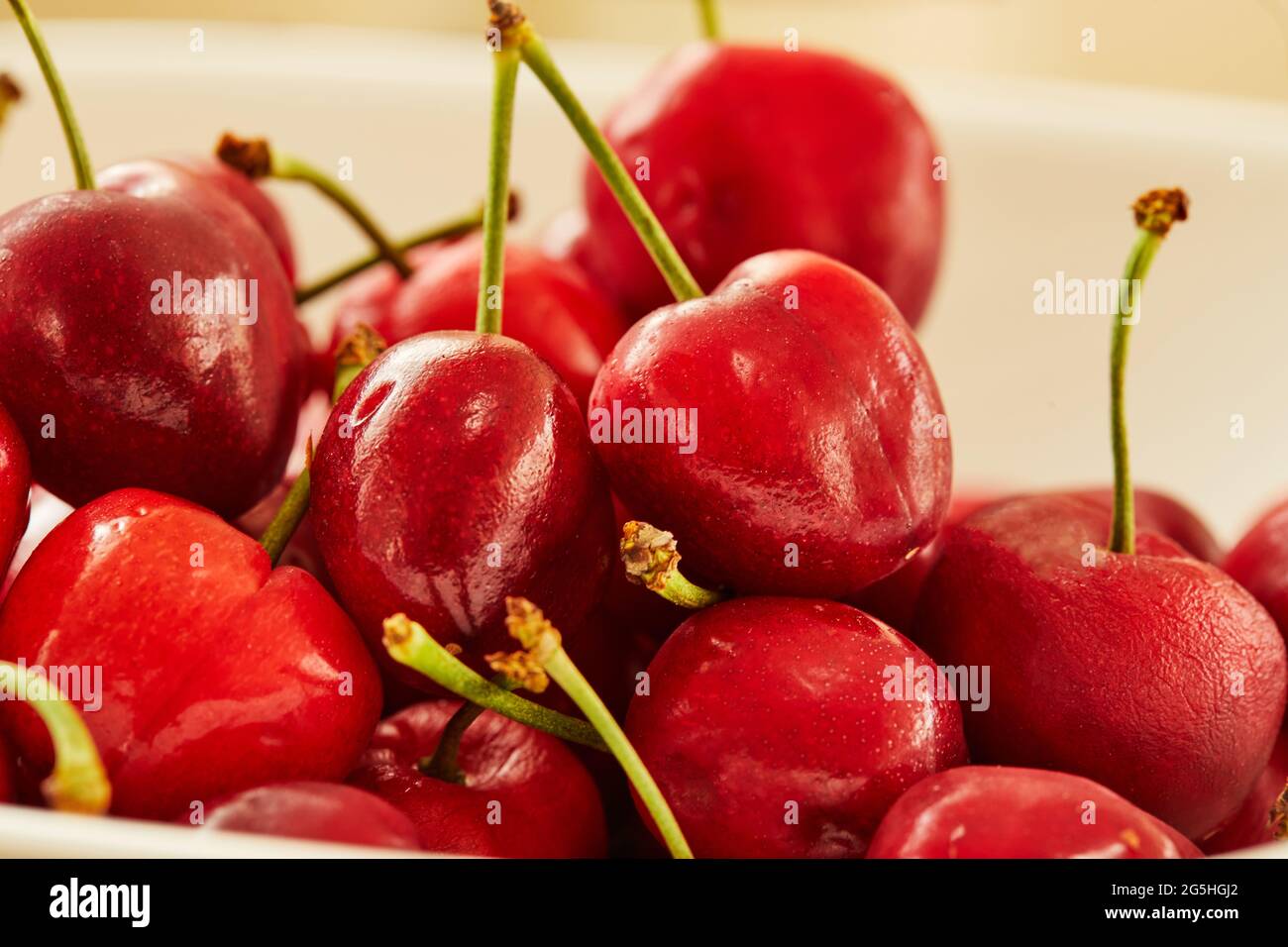 Frische Kirschen auf weißem Teller, fertig zum Essen Stockfoto