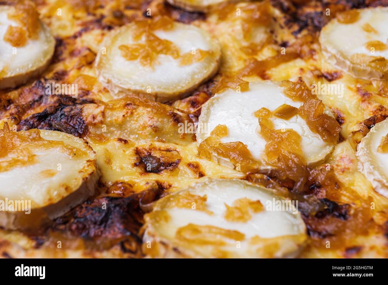 Nahaufnahme der Pizza mit Ziegenkäse und karamellisierten Zwiebeln. Makroaufnahme köstlicher Produkte. Stockfoto