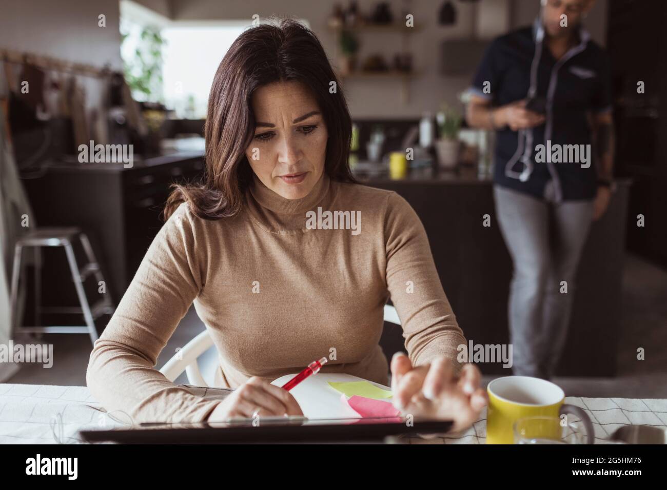 Geschäftsfrau, die im Heimbüro an einem digitalen Tablet arbeitet Stockfoto