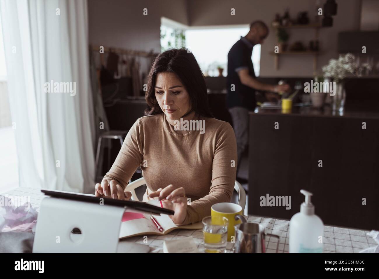 Weibliche Unternehmerin, die zu Hause am digitalen Tablet arbeitet Stockfoto
