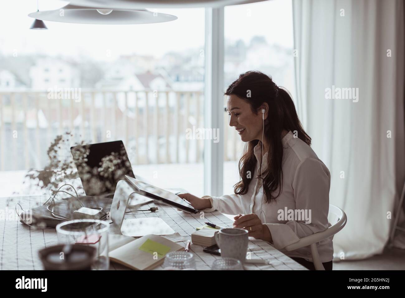 Lächelnde Geschäftsfrau mit digitalem Tablet im Heimbüro Stockfoto