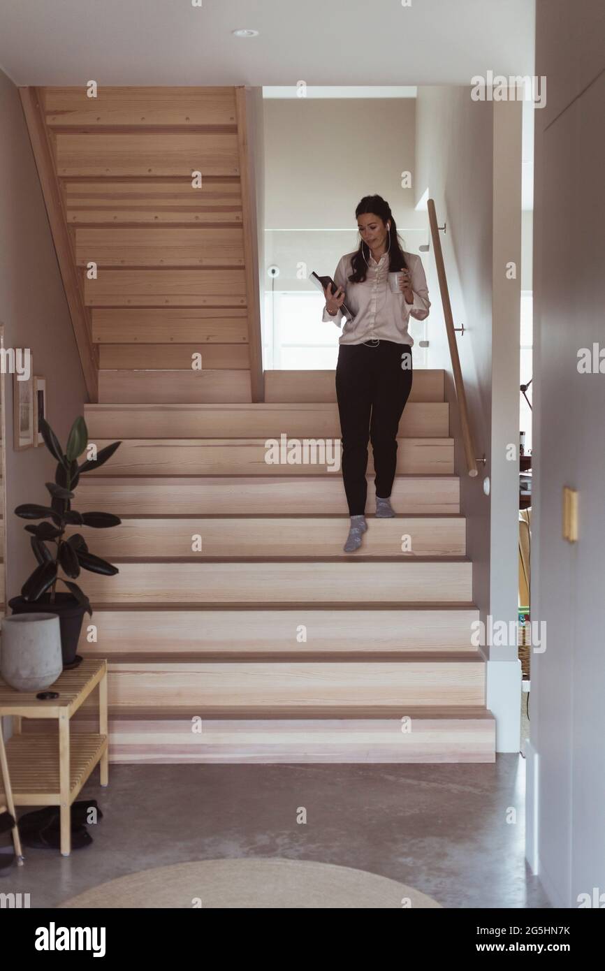 Geschäftsfrau, die im Heimbüro nach unten geht Stockfoto