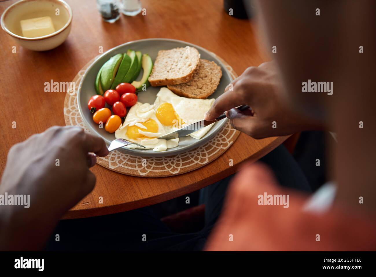 Junger afrikanischer Mann, der ein hausgemachtes Frühstück isst Stockfoto