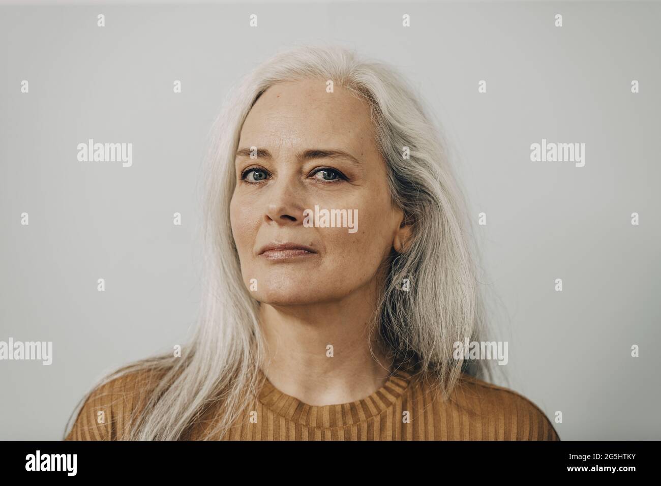 Porträt von Reife Frau vor weißem Hintergrund Stockfoto