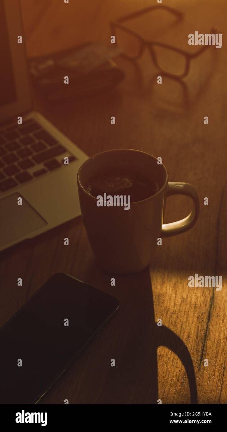 Morgenkaffee in dunklem Home-Office-Innenraum, Low-Key-Bild mit selektivem Fokus Stockfoto