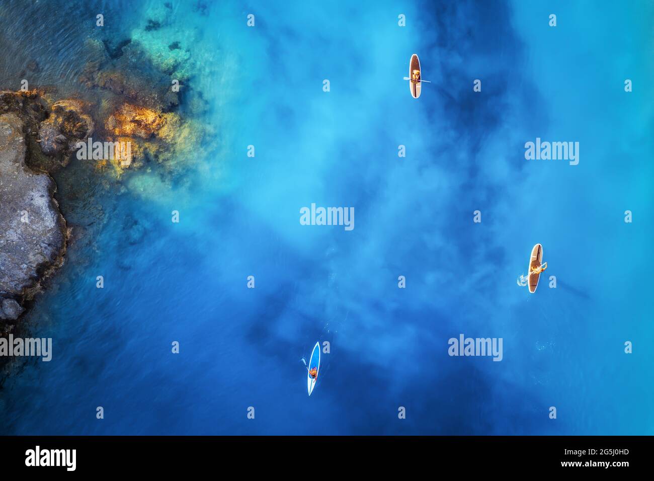 Luftaufnahme von Menschen auf schwimmenden Schautafeln auf blauem Meer Stockfoto