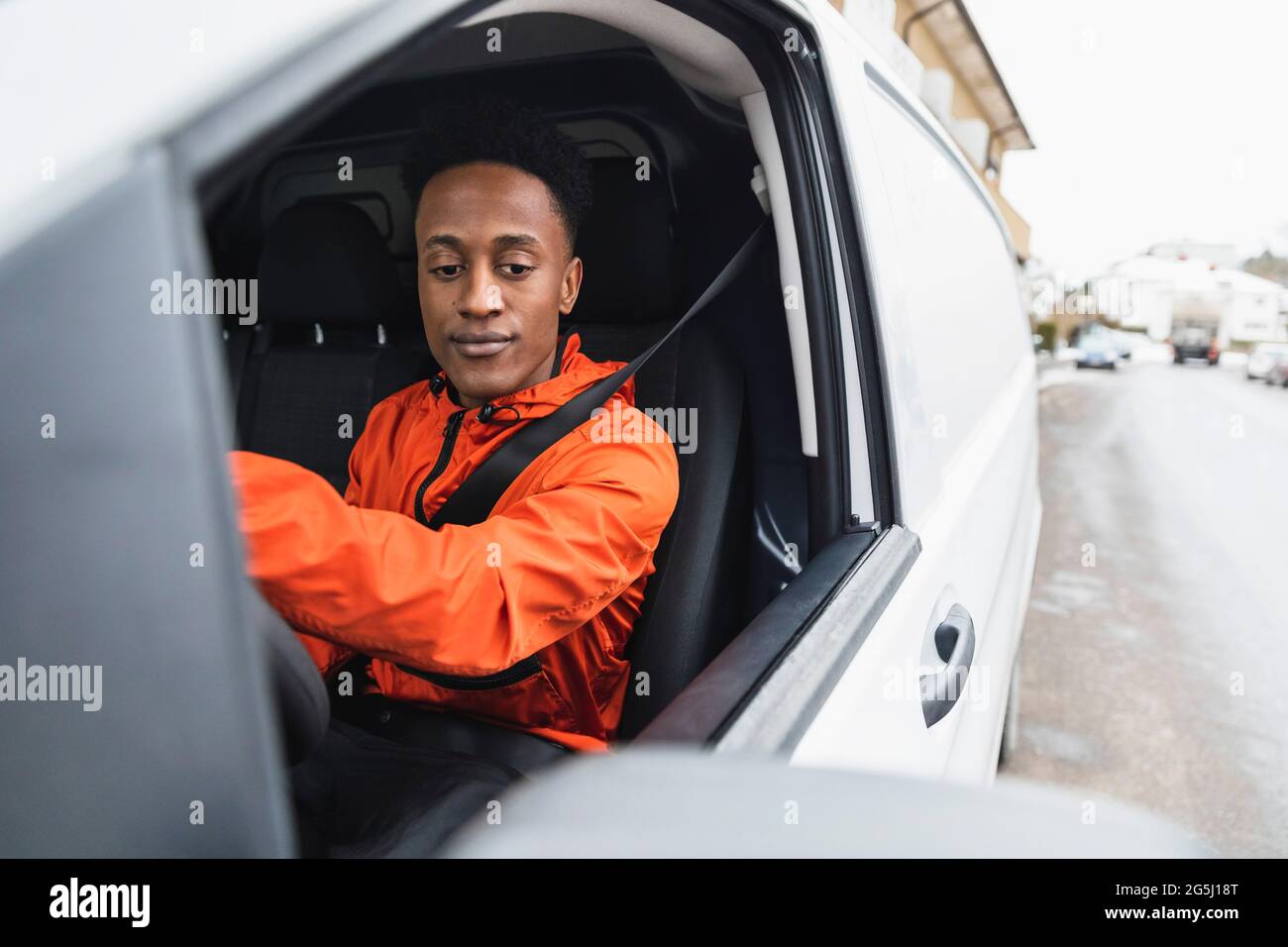 Junger männlicher Fahrer fährt Lieferwagen Stockfoto