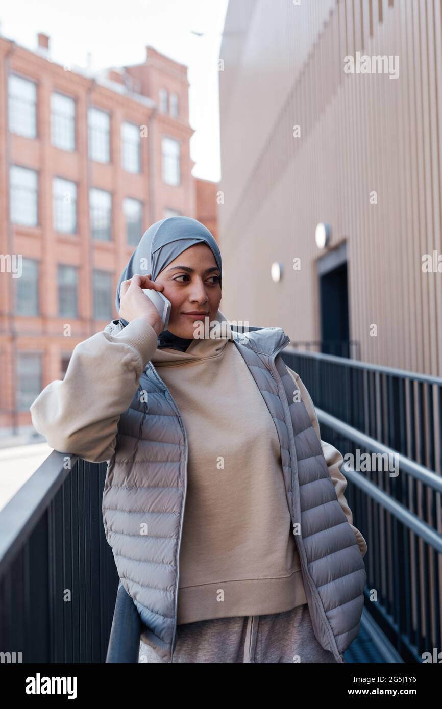 Vertikale Taille nach oben Porträt der modernen Frau aus dem Nahen Osten sprechen mit dem Smartphone in der Stadt, kopieren Raum Stockfoto