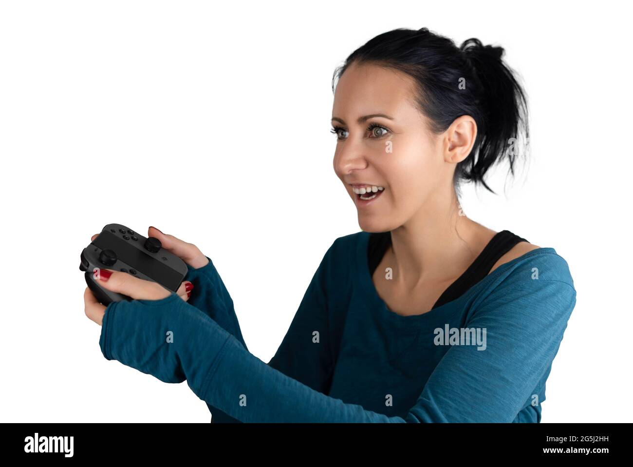 Eine lächelnde, glückliche, konzentrierte junge kaukasische Frau mit einem drahtlosen Joypad aufgeregt Fokussierung spielen ein Spaß digitalen Online-Videospiel Stockfoto