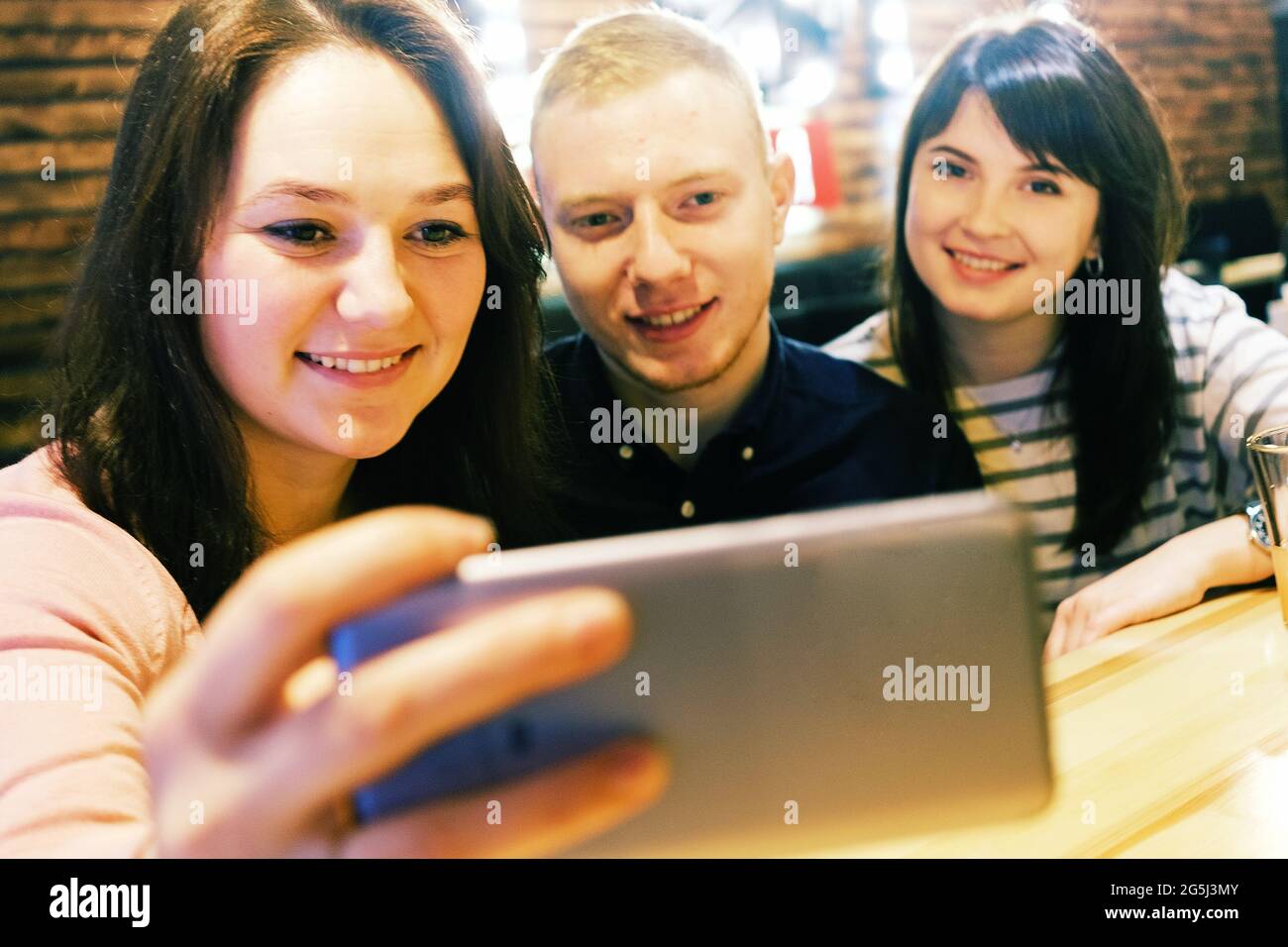Treffen Sie Freunde in einem Café, und sie machen ein Selfie und lächeln - EINE Gruppe von Millennials in einem Café haben Spaß und lachen - Junge Menschen machen ein Selfie Stockfoto
