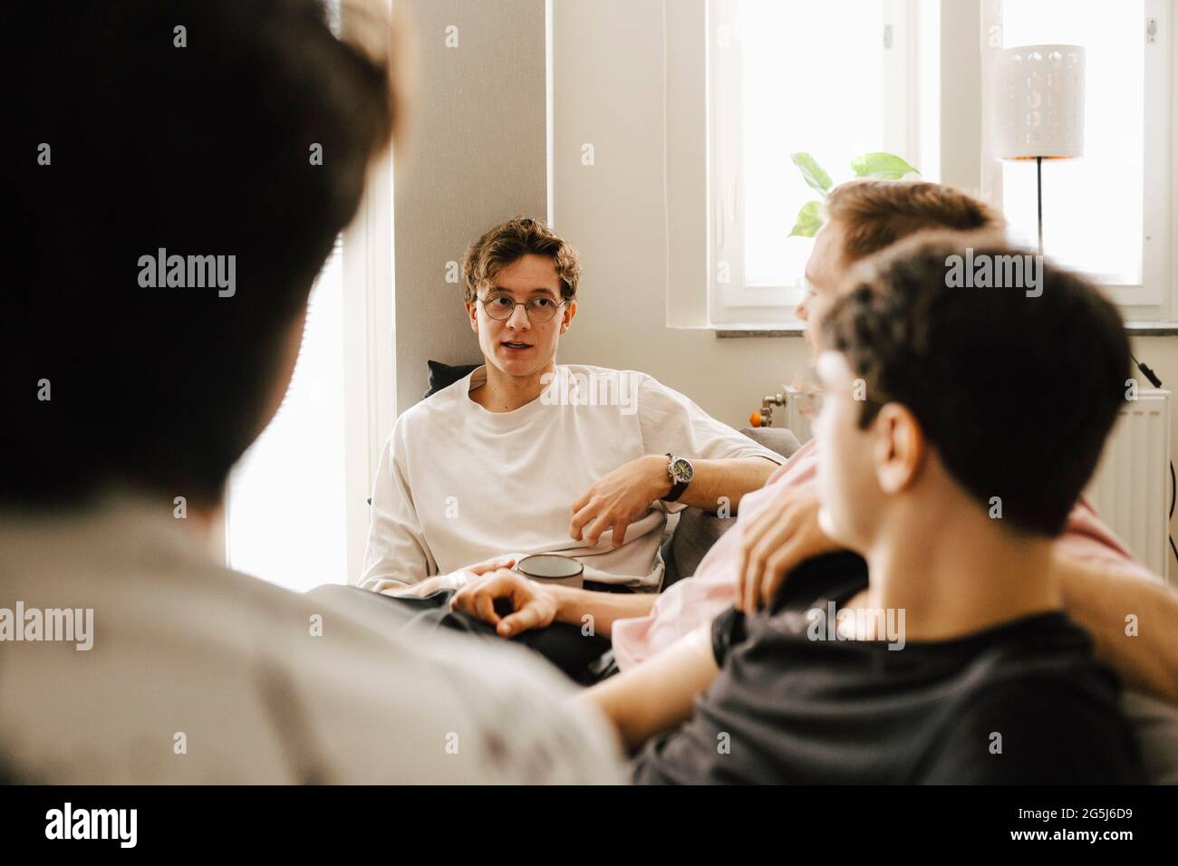 Junge multiethnische männliche Freunde, die Freizeit zu Hause verbringen Stockfoto
