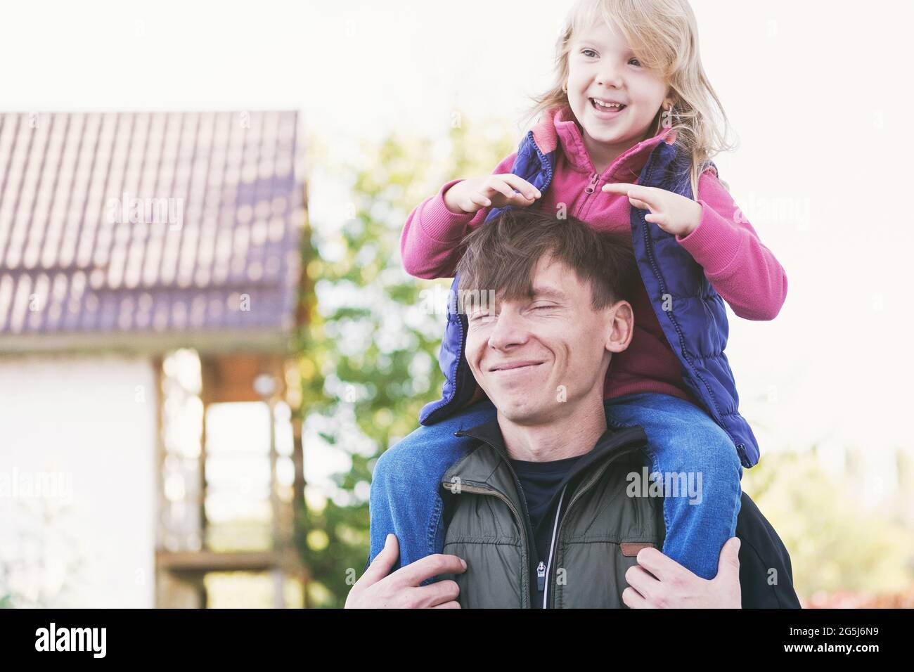 Vater und Tochter haben Spaß zusammen - Single Papa spielt mit Tochter und hält sie auf seinen Schultern - Happy Parent-Child Relationship Concept Stockfoto