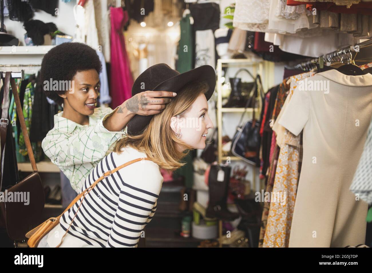 Ladenbesitzerin versucht, sich in der Boutique auf weibliche Kundin zu behüten Stockfoto