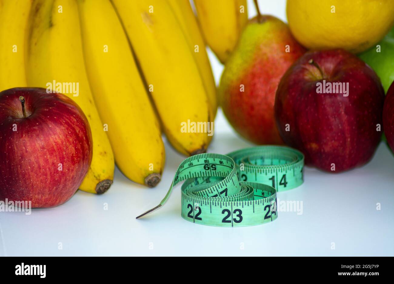 Set aus frischen Früchten, gesunden Früchten mit Maßband auf weißem Hintergrund. Diät-Konzept Stockfoto
