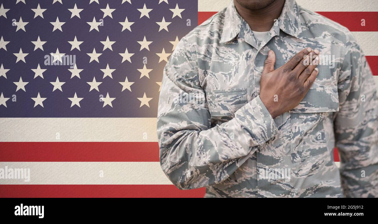 Zusammensetzung des Mittelteils des Soldaten mit Hand auf Herz, gegen amerikanische Flagge Stockfoto