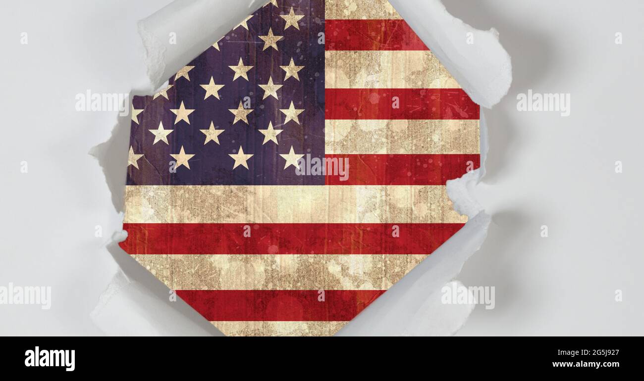 Komposition aus Loch, das in weißem Papier zerrissen wurde und eine alte amerikanische Flagge zeigt Stockfoto