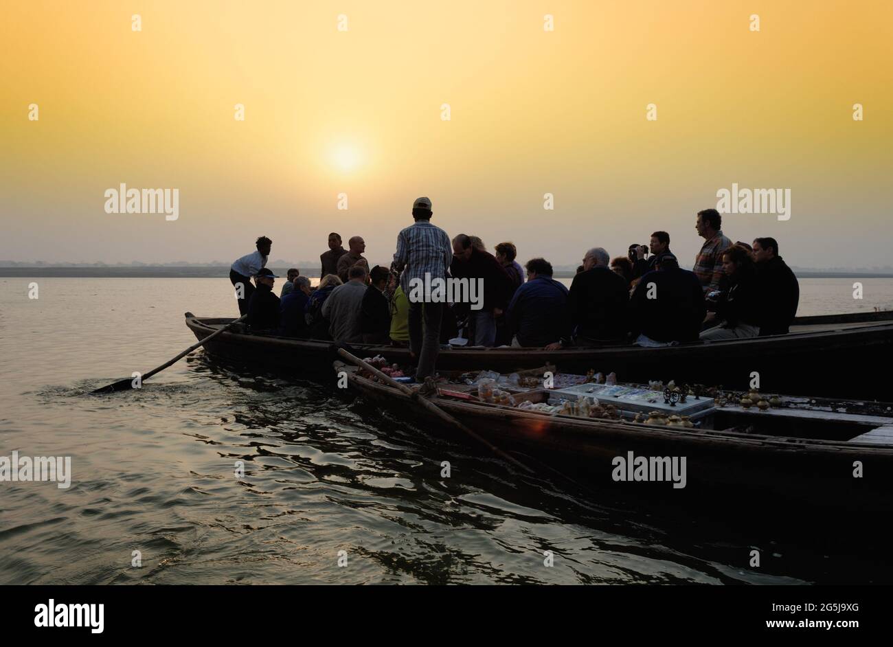 Boote von Touristen und Souvenirverkäufern im Morgengrauen und frühen Morgen auf dem Fluss Ganges in Varanasi, Uttar Pradesh, Indien Stockfoto