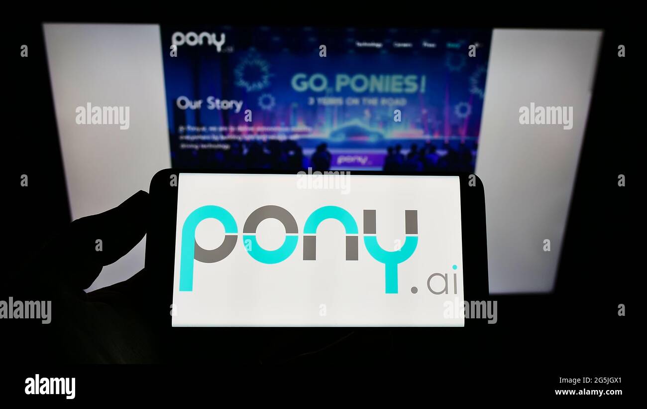 Person, die das Smartphone mit dem Logo des autonomen Fahrzeugunternehmens Pony.AI Inc. Auf dem Bildschirm vor der Website hält. Konzentrieren Sie sich auf die Telefonanzeige. Stockfoto
