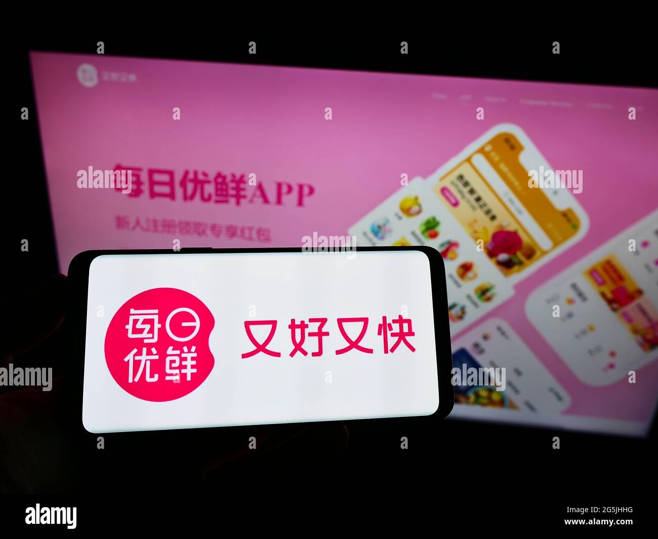 Person, die Mobiltelefon mit dem Logo der chinesischen Firma Beijing Missfresh E-Commerce Co. Ltd. Auf dem Bildschirm vor der Webseite hält. Konzentrieren Sie sich auf die Telefonanzeige. Stockfoto