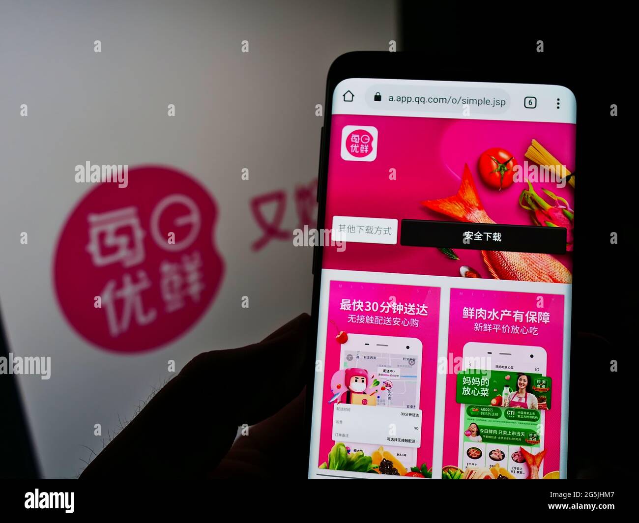 Person, die Mobiltelefon mit Webseite der chinesischen Firma Beijing Missfresh E-Commerce Co. Ltd. Auf dem Bildschirm mit Logo hält. Konzentrieren Sie sich auf die Mitte des Telefondisplays. Stockfoto