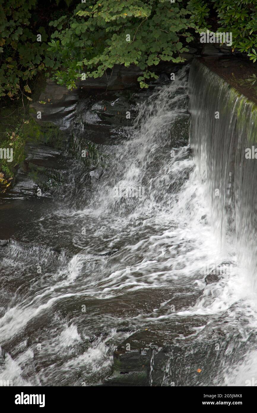 Wasser, das über einen künstlichen Steinwasserfall oder Wehr fließt, wird vom Aberdulais Waterwheel, Neath, Wales, abgeleitet Stockfoto