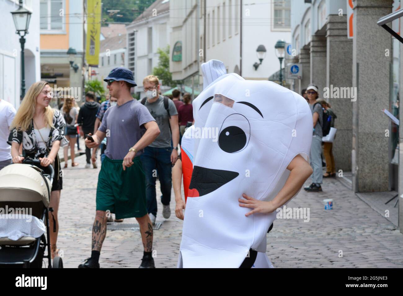 Freiburg im Breisgau, 26. Juni 2021: Die »Zahn« wirbt in der Rathausgasse für eine Zahnpasta, aber nur wenige Besucher nehmen davon Notiz. Stockfoto