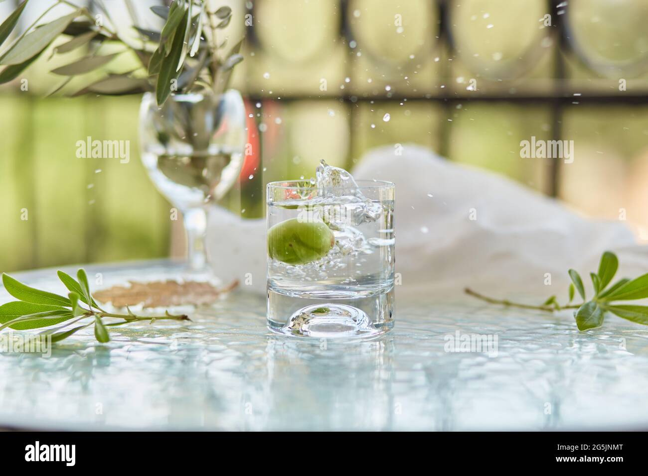 Sommer elegante hausgemachte Cocktails auf dem Hintergrund. Die dekorativen grünen Blätter blühen und der Zweig des Olivenbaums im Glas. Glyphe von Purificat Stockfoto