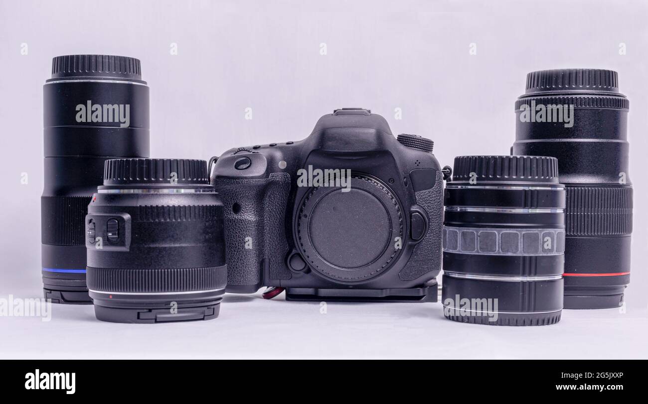 Sammlung von Kameraausrüstung einschließlich eines Kameragehäuses und vier Objektiven auf weißem Hintergrund Stockfoto