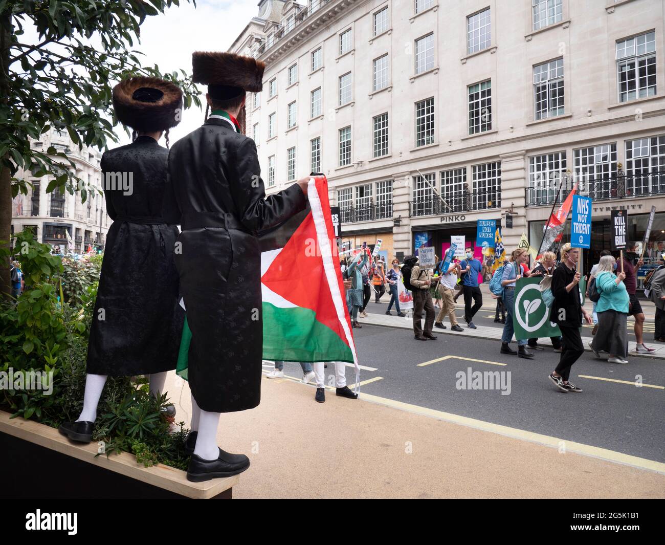 Ultra-orthodoxe Juden der Neturei Karta Division aus Stamford Hill, die gegen den Zionismus unter palästinensischen Flaggen zusammengeschlossene orthodoxe Juden repräsentieren, nehmen an der Volksversammlung National Demonstration in London Teil. Rabbi Blyer befindet sich auf der rechten Seite Stockfoto