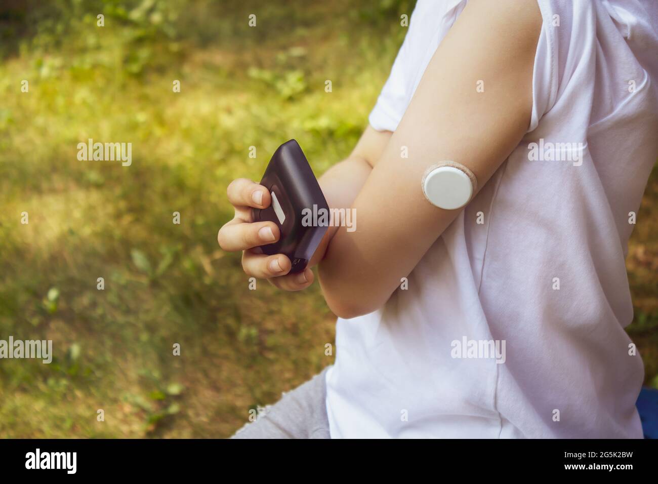 Sommerurlaub, ein Spaziergang im Wald: Ein Diabetiker, der Sport macht, misst den Blutzucker mithilfe eines Zuckerüberwachungssystems im Freien Stockfoto