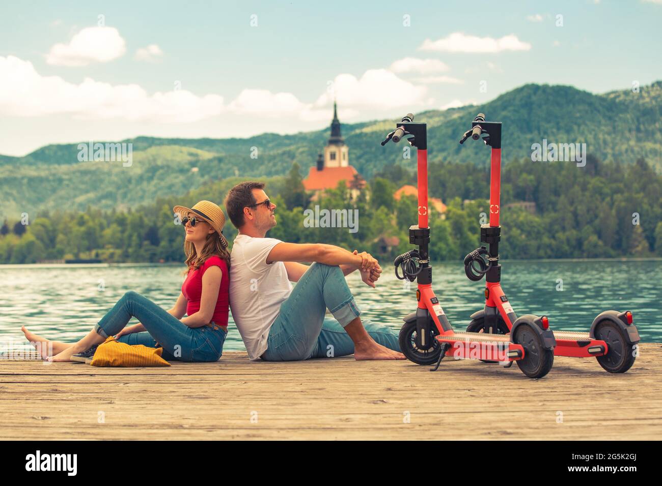 Junges Paar mit Elektroroller als modernes ökologisches Transportmittel während der Erkundung des grünen Landes Slowenien im Urlaub. Grüne Öko-Energie Stockfoto