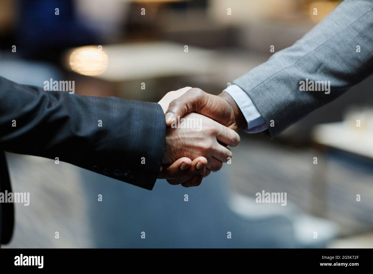 Nahaufnahme von zwei erfolgreichen Geschäftsleuten, die in der Lobby des Bürogebäudes die Hände schütteln, Kopierfläche Stockfoto
